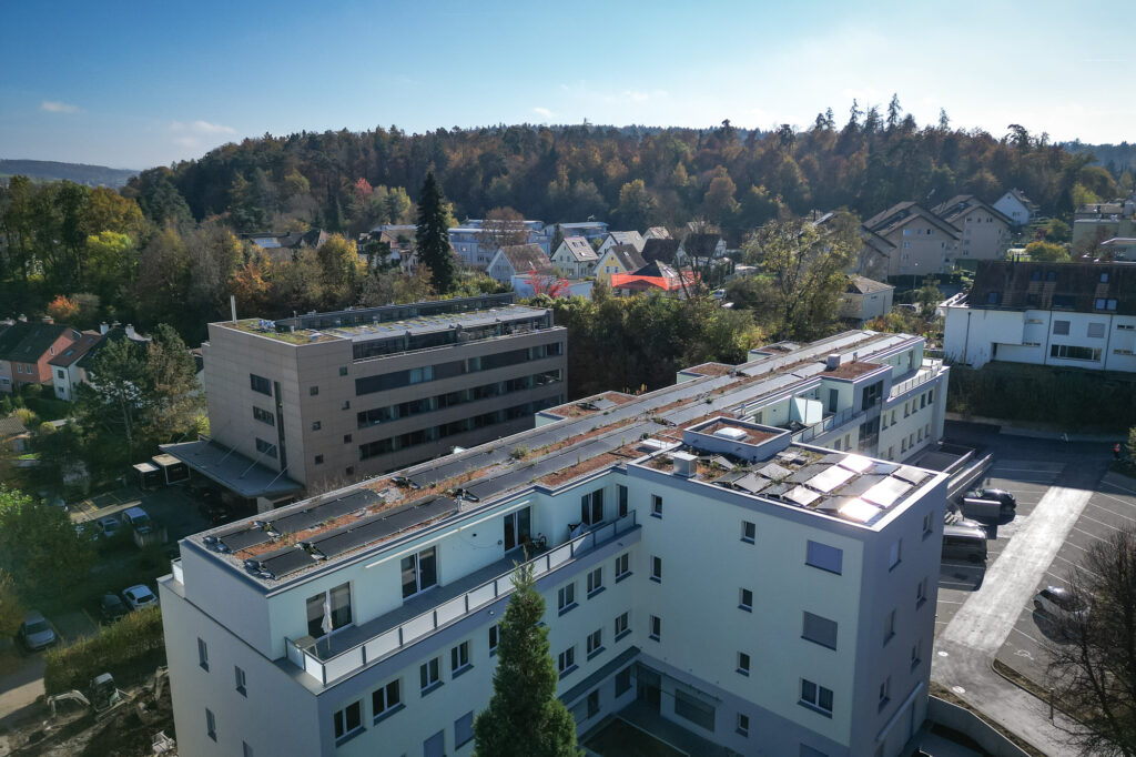Mehrfamilienhaus mit Solaranlage der Scherrer Metec AG im Gegenlicht.